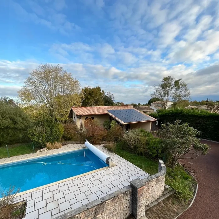 Vue extérieure d'une maison individuelle avec piscine privée au premier plan