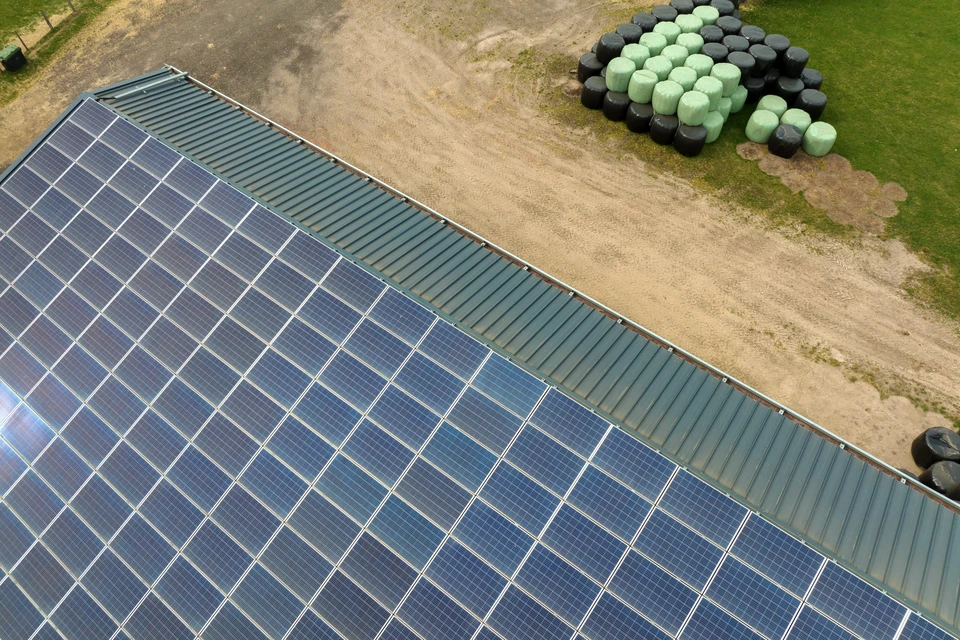 Vue aérienne de panneaux solaires photovoltaïques bleus montés sur le toit de la ferme pour produire de l'électricité écologique propre