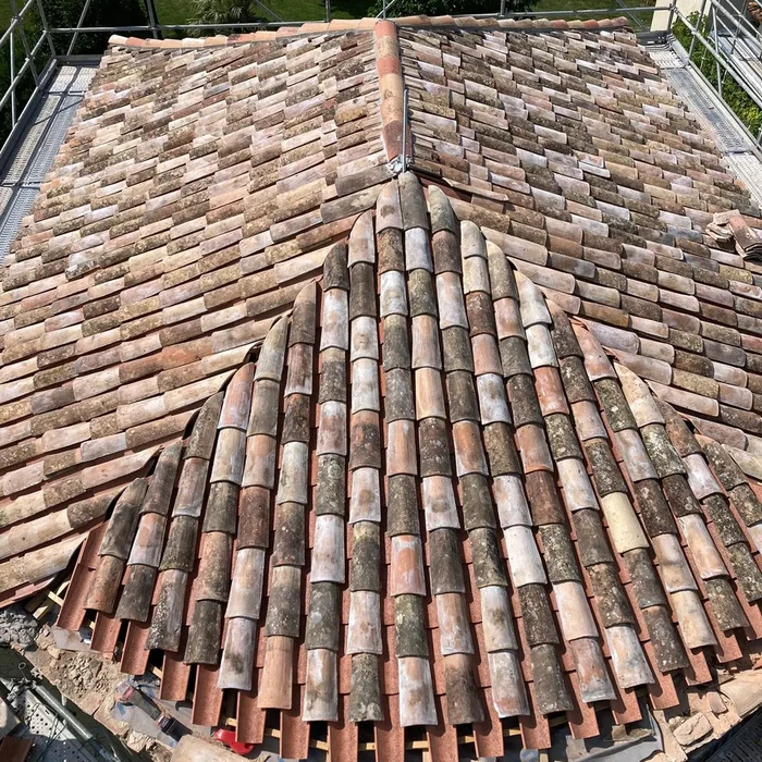 Vue extérieure d'une toiture en tuiles canal de terre cuite disposées en arêtier