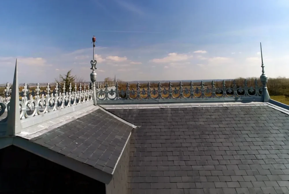 Scène extérieure sur toiture d'édifice avec ouvrier effectuant travaux de maintenance