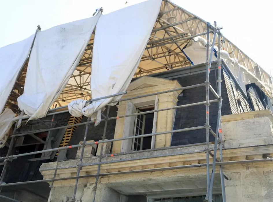 Chantier de rénovation extérieure d'une maison avec échafaudage métallique tubulaire et garde-corps de sécurité