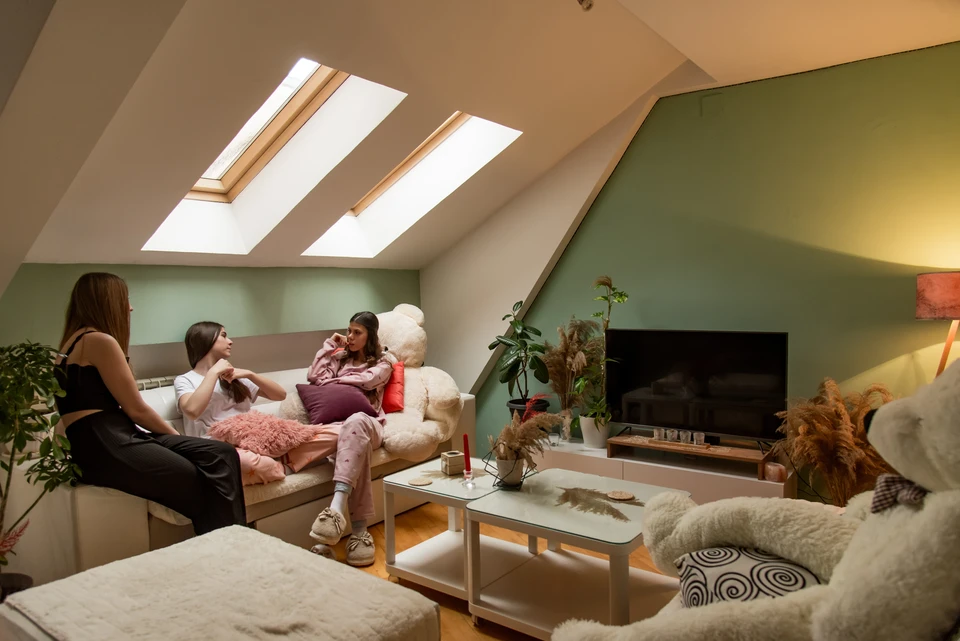 Cuisine moderne sous combles avec poutres apparentes en bois massif, murs en briques blanches peintes