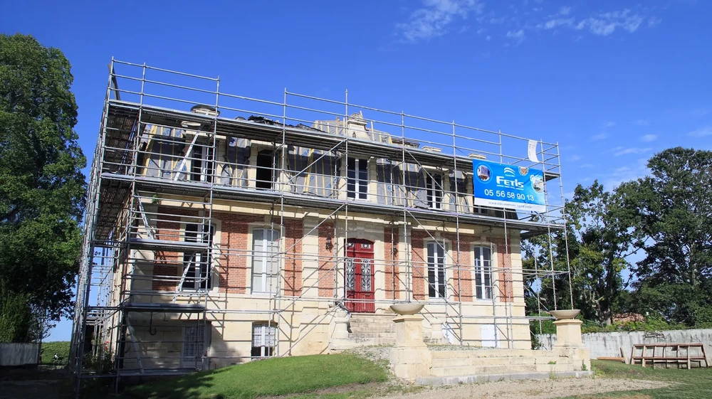 Toiture en tuiles canal rouges sous ciel bleu avec soleil couchant