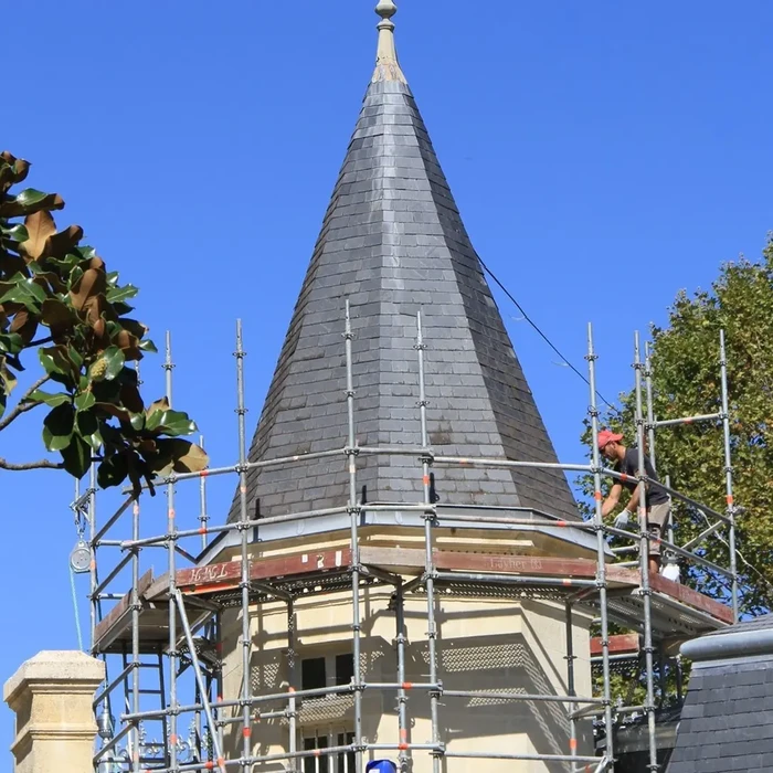 Toiture résidentielle avec installation de panneaux solaires photovoltaïques noirs sur couverture en tuiles canal terre cuite