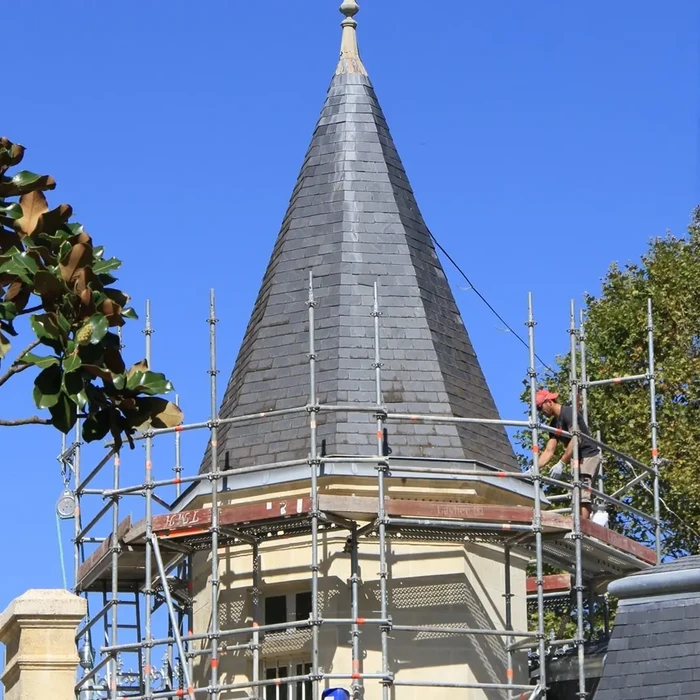 Chantier de toiture en cours avec ouvrier effectuant des travaux de couverture