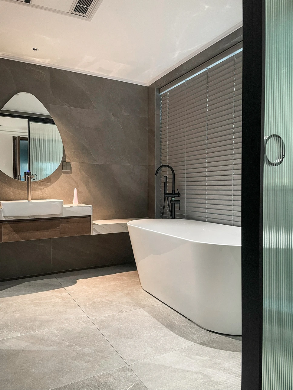 Int&eacute;rieur de salle de bain, personne actionnant un robinet chrom&eacute; pour se laver les mains