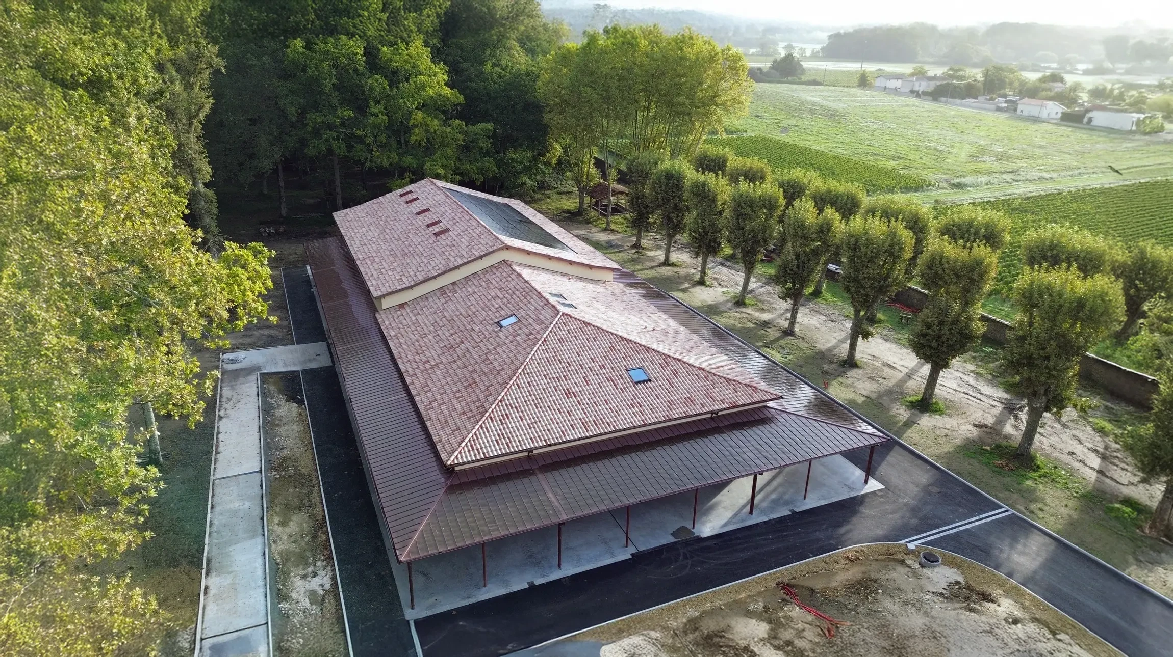 Toitures en tuiles terre cuite rouge-brun avec lucarnes &agrave; fen&ecirc;tres blanches, murs cr&eacute;pi beige