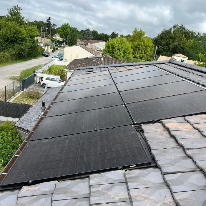 Chantier de couverture en extérieur avec deux couvreurs installant une toiture métallique